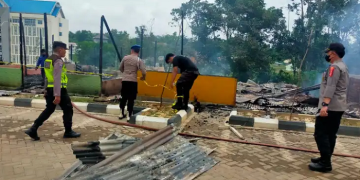 Kapolsek Jaluko terlihat sedang memegang tabung racun api untuk membantu menjinakan si jago merah yang menghanguskan 5 kantin di kampus UIN STS Jambi, Selasa (27/12/2022). [Humas Polres Muaro Jambi]