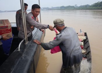 Kapolda Jambi menyerahkan bantuan kepada nelayan yang sedang mencari ikan, yang ia temui di pinggiran Sungai Batanghari Selasa (3/1/2023). [Humas Polda Jambi]