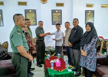 Kasrem 042/Garuda Putih (Gapu), Kolonel Inf Ali Aminudin dan Ketua Komisi Informasi Provinsi Jambi, Indra Lesmana bersalaman dan foto bersama usai melakukan audiensi di Makorem 042/Gapu, Kamis (2/2/2023). [Penrem 042 Gapu/Hatta]