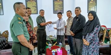 Kasrem 042/Garuda Putih (Gapu), Kolonel Inf Ali Aminudin dan Ketua Komisi Informasi Provinsi Jambi, Indra Lesmana bersalaman dan foto bersama usai melakukan audiensi di Makorem 042/Gapu, Kamis (2/2/2023). [Penrem 042 Gapu/Hatta]