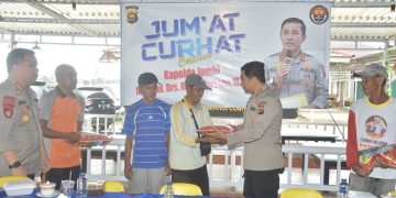 Kabid Humas Polda Jambi, Kombes Pol Mulia Prianto, menyerahkan bantuan beras kepada salah satu masyarakat yang hadir dalam kegiatan Jum'at Curhat, (10/2/2023). [Foto Humas Polda Jambi]