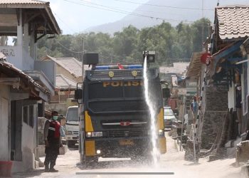Mobil Armoured Water Canon Sat Samapta Polresta Magelang saat melakukan pembersihan jalan yang tertutup abu vulkanik di jalan Desa Krinjing, Kabupaten Magelang pada, Minggu (12/3/2023) pagi. [Dok. Humas Polresta Magelang]