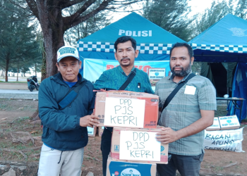 Ketua Komunitas Penikmat Kopi Pantai Piwang (tengah) menerima bantuan dari DPD PJS Kepri Sekretaris DPD (kiri) Bendahara DPD (kanan) di posko bantuan Ranai. [Foto: DPD PJS Kepulauan Riau]