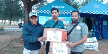 Ketua Komunitas Penikmat Kopi Pantai Piwang (tengah) menerima bantuan dari DPD PJS Kepri Sekretaris DPD (kiri) Bendahara DPD (kanan) di posko bantuan Ranai. [Foto: DPD PJS Kepulauan Riau]