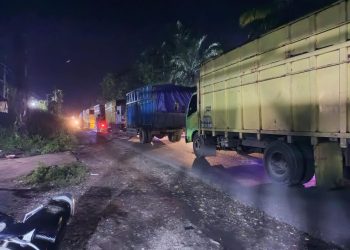 Deretan truk angkutan batu bara yang melintas di lokasi macet di Jalan Muaratembesi - Sarolangun, Rabu malam (1/2/2023). [Foto: Aldo]