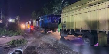 Deretan truk angkutan batu bara yang melintas di lokasi macet di Jalan Muaratembesi - Sarolangun, Rabu malam (1/2/2023). [Foto: Aldo]