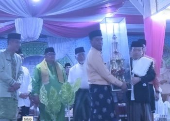 Penyerahan Piala kepada juara umum oleh Gubernur Al Haris. [Dok. Riki]