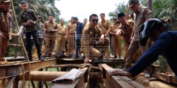 Pj Bupati Muaro Jambi, Bachyuni Deliansyah, saat melakukan peninjauan pembangunan jembatan Sungai Kandang di Kecamatan Sungai Bahar, Senin (6/3/2023). [Dok. Diskominfo Muaro Jambi]