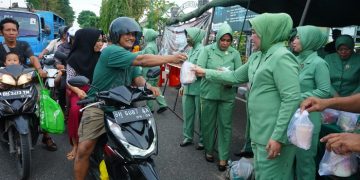 Ketua Persit Kartika Chandra Kirana Koorcab Rem 042 PD II/Sriwijaya Ny. Wiwik Supriono bersama Pengurus saat membagikan takjil buka puasa kepada masyarakat yang melintasdi depan Makorem 042/Gapu, Kota Jambi, Jumat (31/03/2023). [Dok. Penrem 042/Gapu-Hatta]