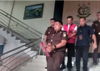 Dirut Bank 9 Jambi, El Hacon menggunakan rompi ungu dengan tangan di borgol. [Dok. Aurduri.com/Reza]