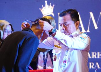 Gubernur Al Haris saat memasang medali kepada siswa pada Pelepasan Siswa Kelas XII SMA Negeri 1 Kota Jambi Angkatan Ke-65, bertempat di Hotel BW Luxury, Rabu (03/05/2023). [Foto: Diskominfo/Patra]