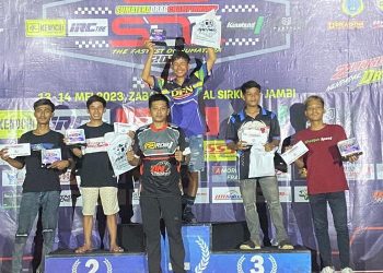 Joki drag race Kodijah Speed saat menerima tropi dari atas podium satu kelas Bracket Time 9. [Foto. Sinsen/Ajeng]