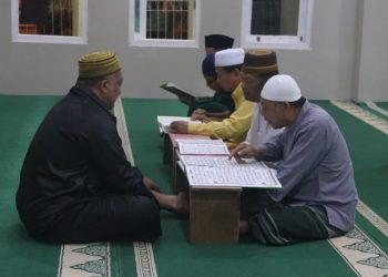 Aiptu Nana Sumarna saat mengajari anak-anak membaca Al-Qur'an di Perumahan Vidya Indah, Kelurahan Lingkar Selatan, Kecamatan Paal Merah, Kota Jambi, Rabu (28/06/2023). [Foto: Humas Polda Jambi]