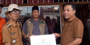 Sekda Sapril saat salurkan bantuan korban musibah angin puting beliung kepada Warga Desa Teluk Majelis, Selasa (16/5/23). [Foto: Diskominfo Tanjabtim]