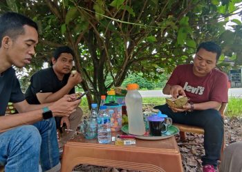 Juanda bersama teman-temannya sedang menyantap durian yang ada di Desa Danau Lamo, Kecamatan Muaro Sebo, Muaro Jambi, Selasa (18/7/2023). [Foto: Aurduri/Ega]