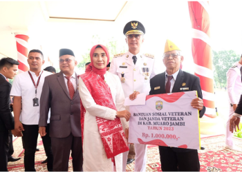 Penjabat (Pj) Bupati Muaro Jambi, Bachyuni Deliansyah, saat memberikan bantuan kepada veteran usai upacara pada Kamis, (17/8/2023). [Foto: Diskominfo Muaro Jambi]
