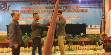 Ketum DPP PJS didamping Sekjen menyerahkan Pataka PJS usai Musda I, Sabtu (05/08/2023). [Foto: DPP PJS Kepri]