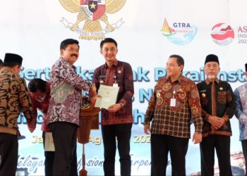 Menteri ATR/BPN Hadi Tjahjanto menyerahkan sertifikat kepada Pj Bupati Bachyuni dalam Kunker nya di Kawasan Candi Kedaton Komplek Candi Muaro Jambi, Kabupaten Muaro Jambi pada Kamis, (24/08/2023). [Foto: Diskominfo Muaro Jambi]