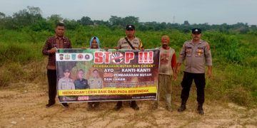 Bhabinkamtibmas Kelurahan Aur Kenali sosialisasikan stop Karhutla kepada masyarakat dengan menggunakan banner, Rabu (29/11/2023).
