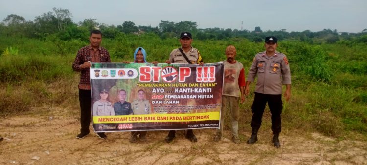 Bhabinkamtibmas Kelurahan Aur Kenali sosialisasikan stop Karhutla kepada masyarakat dengan menggunakan banner, Rabu (29/11/2023).