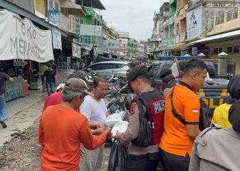 Pembagian ratusan nasi bungkus kepada masyarakat di Pasar Angso Duo Jambi, Jumat (19/1/2024). [Foto: Humas Polda Jambi]
