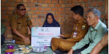 Pj Bupati Najmi saat meninjau dan sekaligus memberikan bantuan kepada masyarakat melalui program bedah rumah di Desa Tunas Mudo dan Desa Sembubuk Kecamatan Sekernan Kabupaten Muaro Jambi, Selasa (21/1). (Foto: Diskominfo)